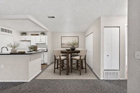 A kitchen with a dining table and chairs.