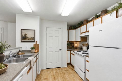 A kitchen with white appliances and wooden floors at Slate Canyon Apartments, Utah, 84606