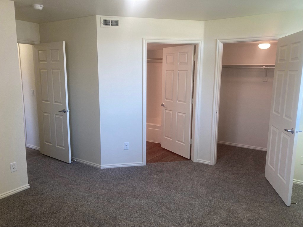 an empty room with three doors and a carpeted floor