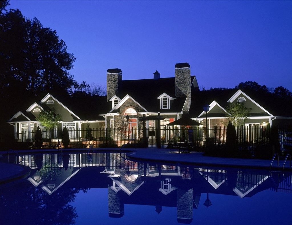 a large pool in front of a house at night