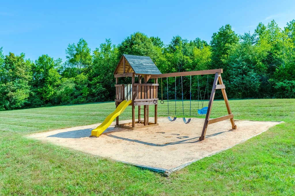 a playground with a swing set in a park