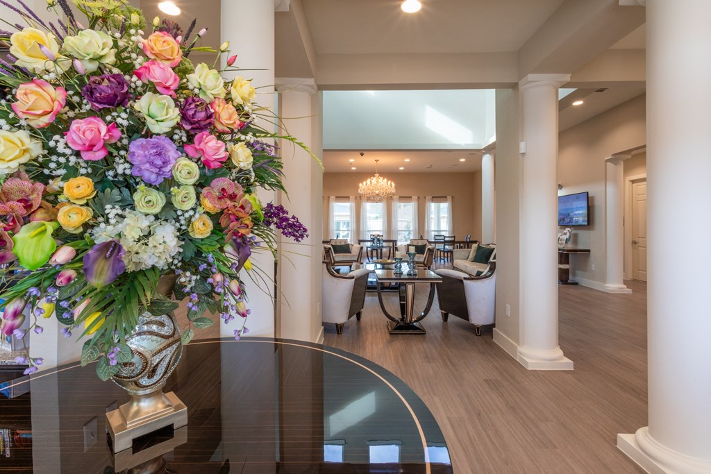 A large floral arrangement sits on a table in a spacious room.