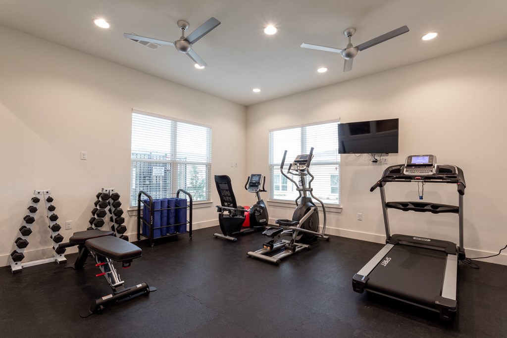 gym with cardio equipment and weights at the district at highland village apartments