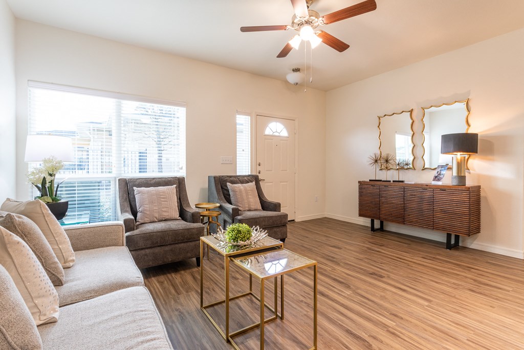 A living room with a couch, chairs, and a coffee table.