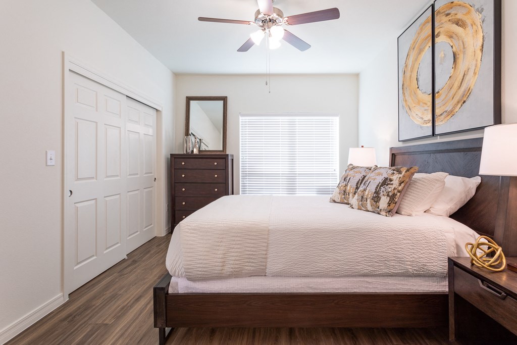 A bedroom with a bed, dresser, and mirror.