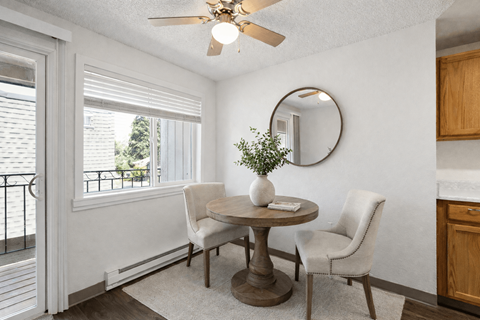 A dining room with a table and chairs.