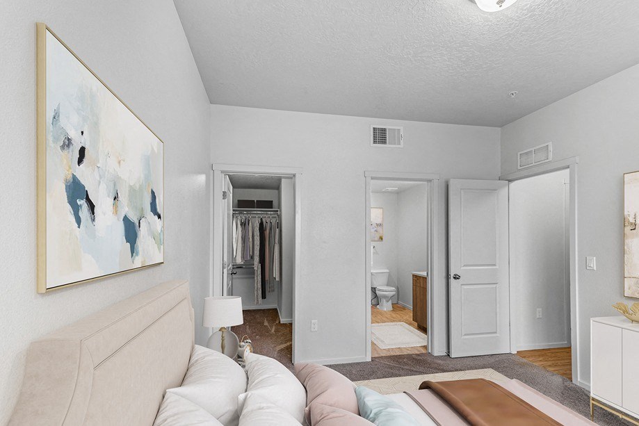 a bedroom with a white couch and a large painting on the wall