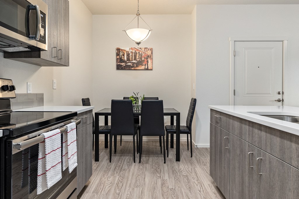 A kitchen with a dining table and chairs.
