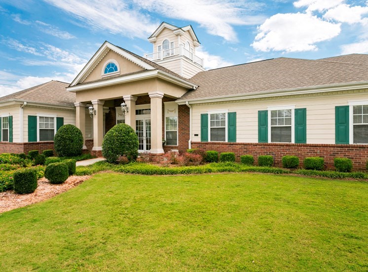 the front of a house with green shutters and a green lawn