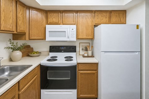 A kitchen with wooden cabinets and a white refrigerator.