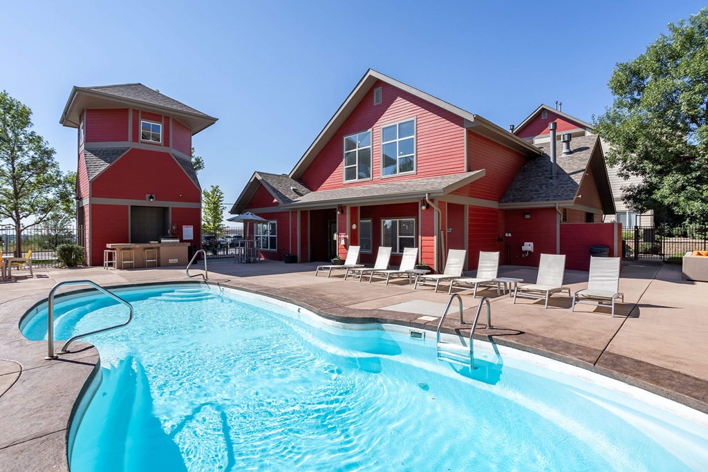 the pool is in front of a red house with a swimming pool the pool is in front of a red house with a swimming pool at Stetson Meadows Apartments, Colorado Springs