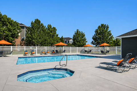 A swimming pool with a slide and sun umbrellas at Haven Pointe Apartments, West Haven, Utah