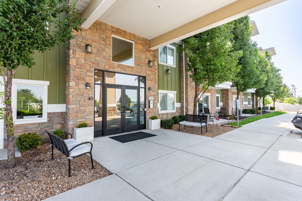 A modern house with a brick facade and a black metal bench.