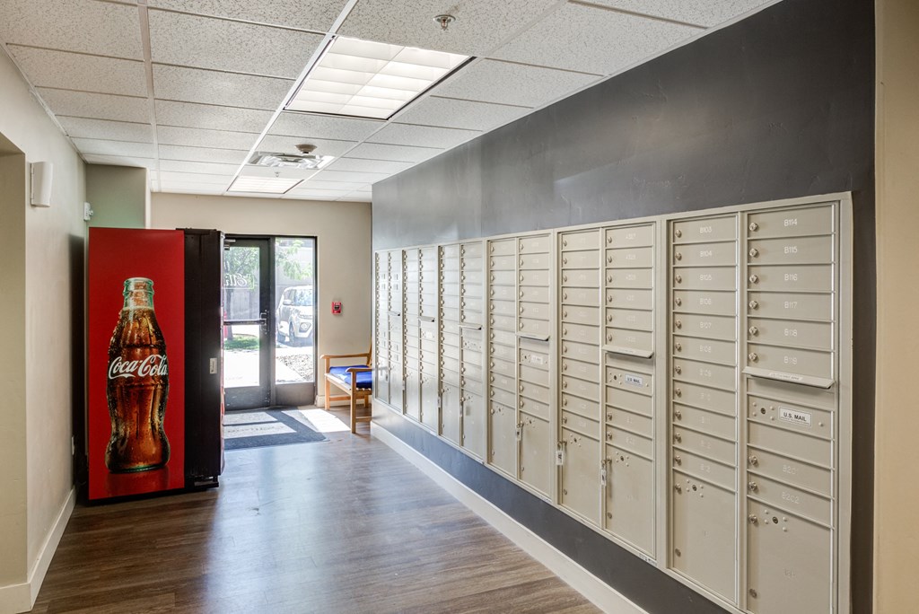 A long hallway with a Coca-Cola machine on the left and mailboxes on the right.