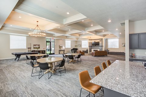 a community room with tables and chairs and a kitchen