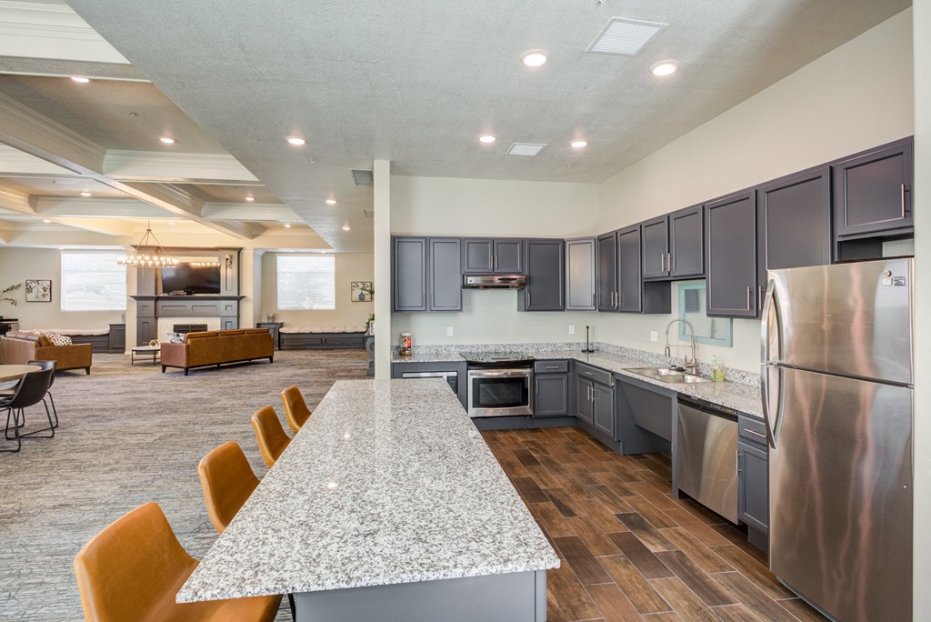 A kitchen with a long table and chairs.