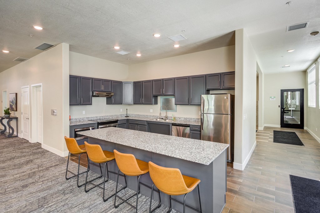 A kitchen with a bar area and chairs.