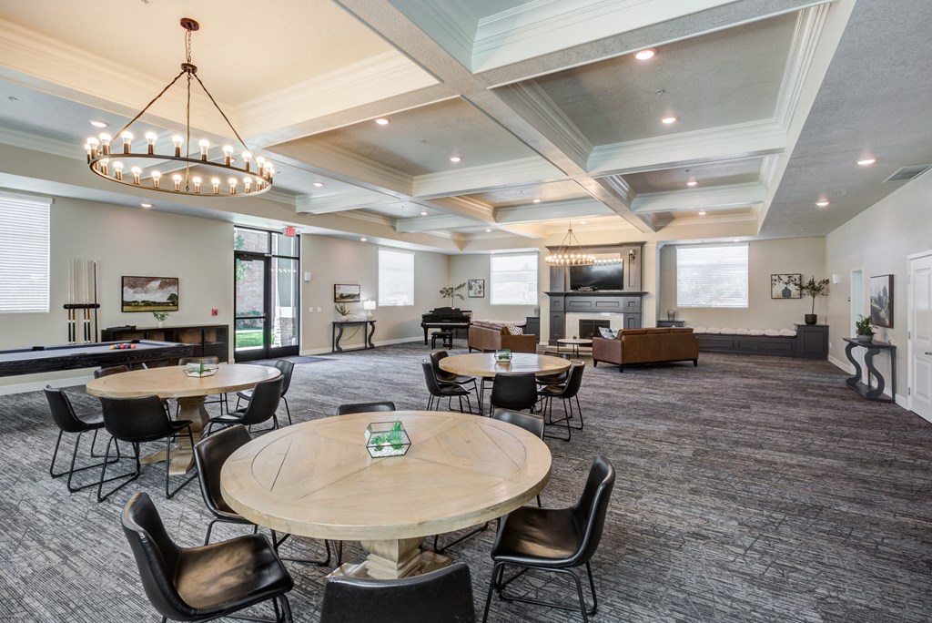 A large room with a round table and chairs in the center.