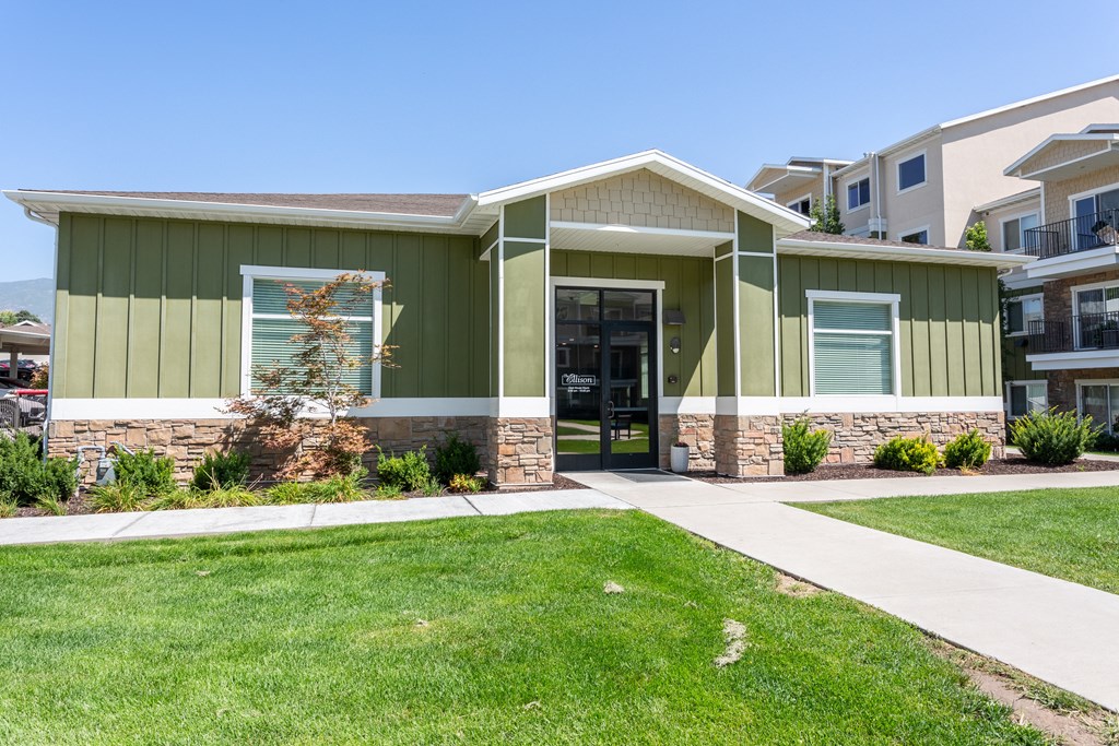 A green building with a white door and windows.