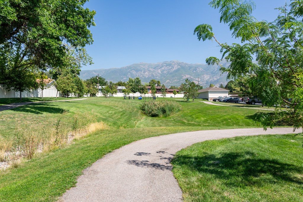 A pathway in a park with a mountain in the background.