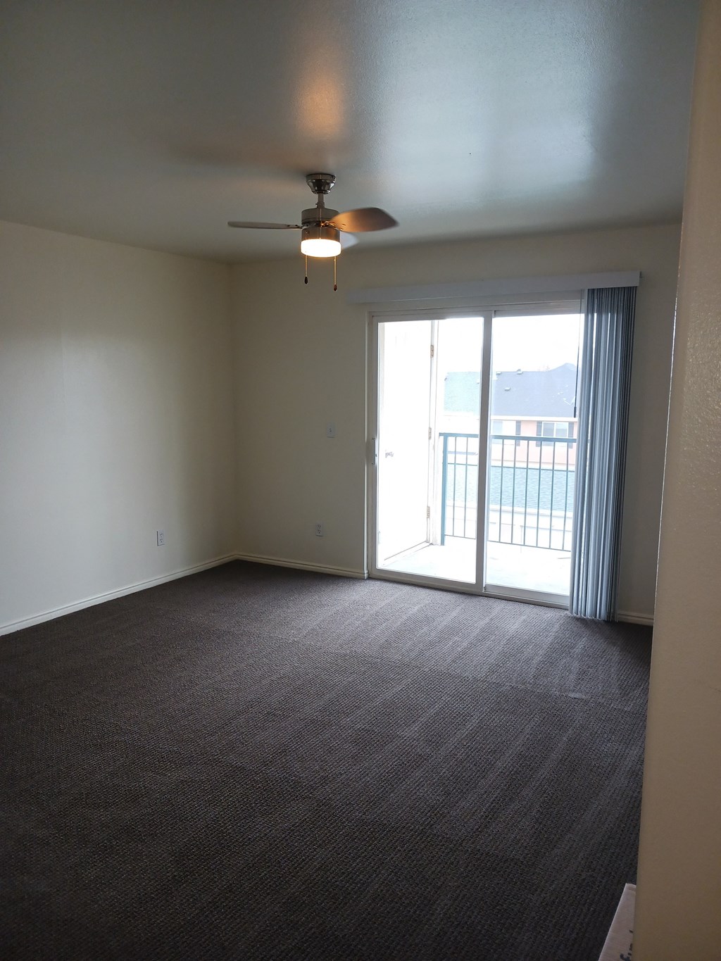 an empty living room with a ceiling fan