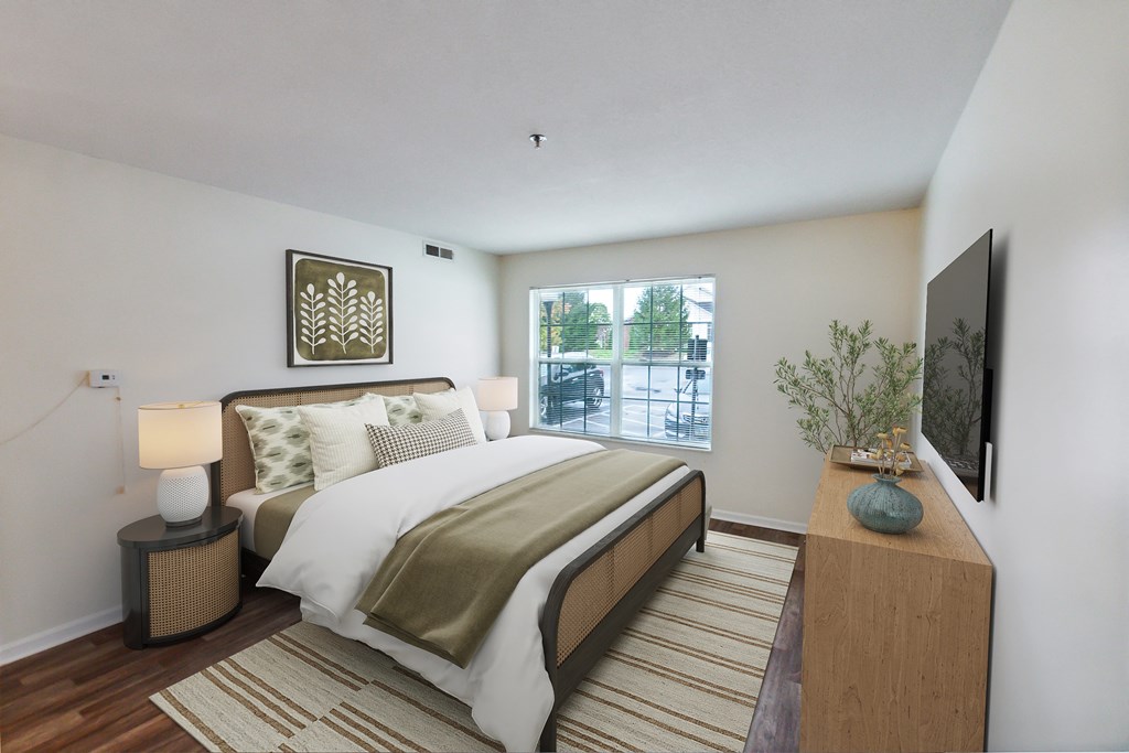 A bedroom with a large bed and a window overlooking a street.