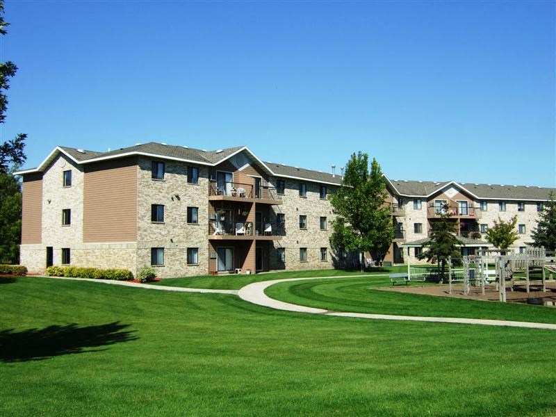 a large apartment building with a green yard
