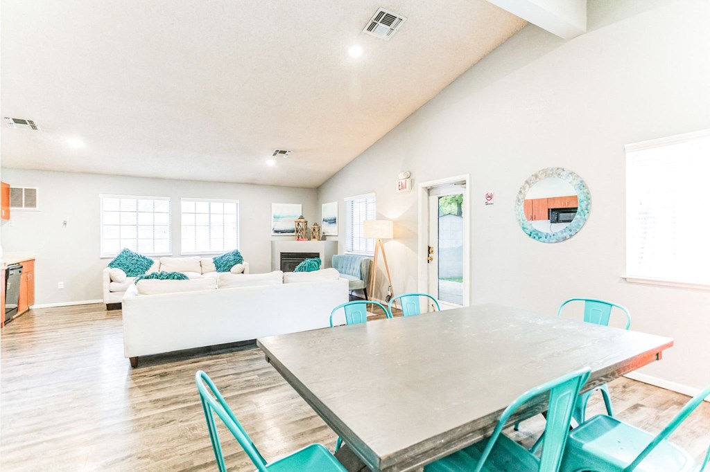 a dining area with a table and chairs and a living room with a couch and a fireplace