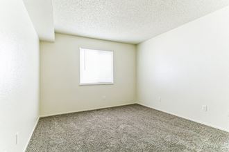 a bedroom with white walls and carpet