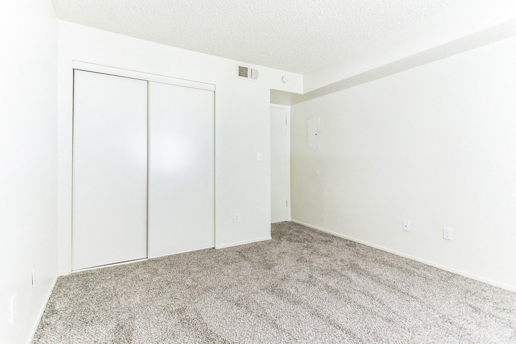 a bedroom with a carpeted floor and white walls