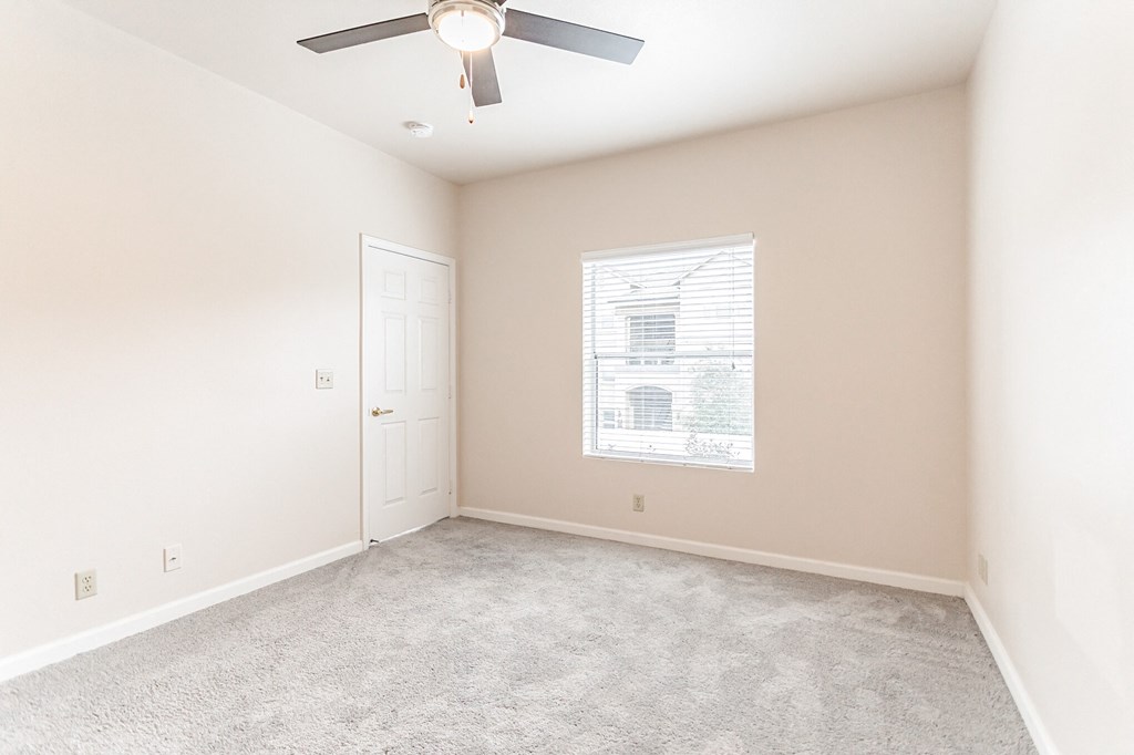 a bedroom with a ceiling fan and a window