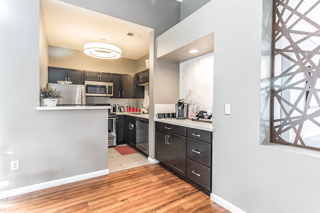 a kitchen with dark cabinets and a wood floor