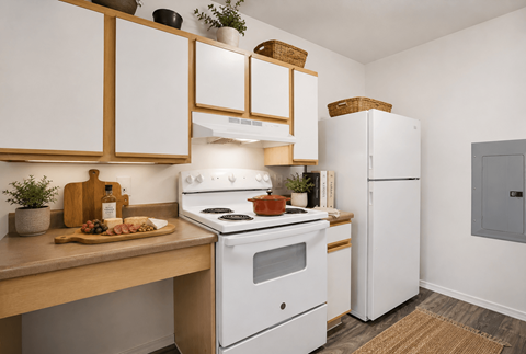 A kitchen with white appliances and wooden cabinets.