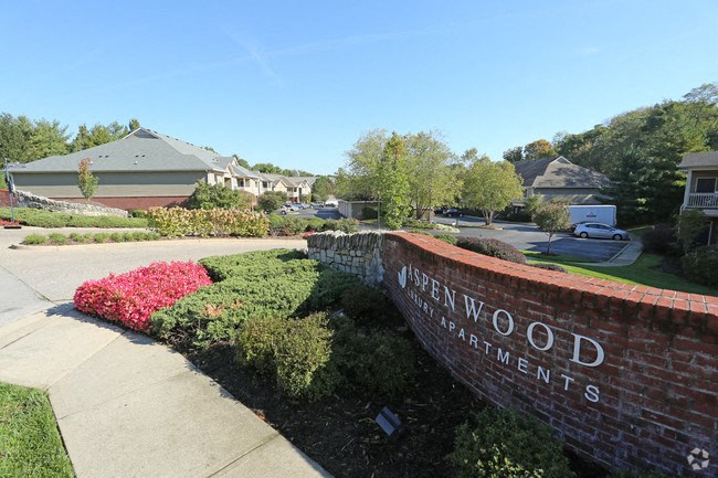 a brick retaining wall with the newwood apartments sign