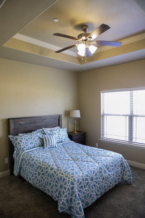 a bedroom with a bed and a ceiling fan