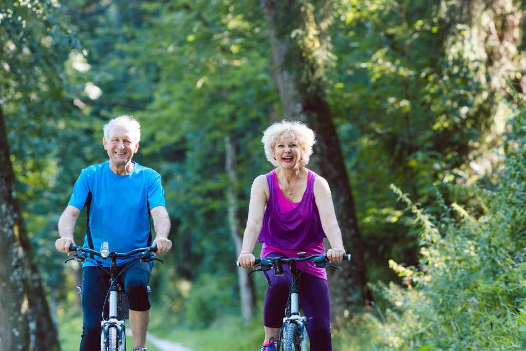a man and a woman riding bikes in a park