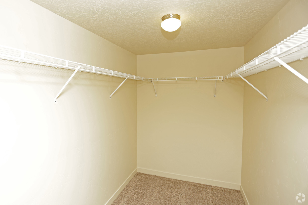 an empty bedroom with a white closet and a light on the ceiling