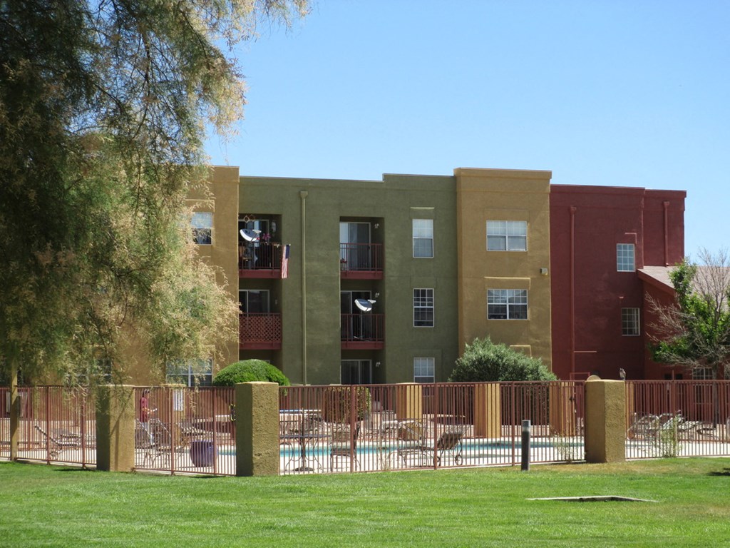 an apartment building with a fence in front of it