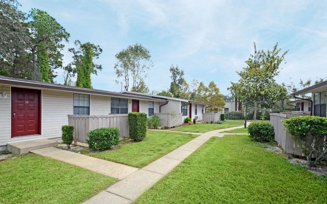 a row of mobile homes in a yard with a sidewalk