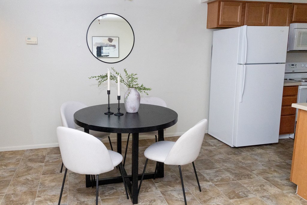 a dining room with a table and chairs and a refrigerator