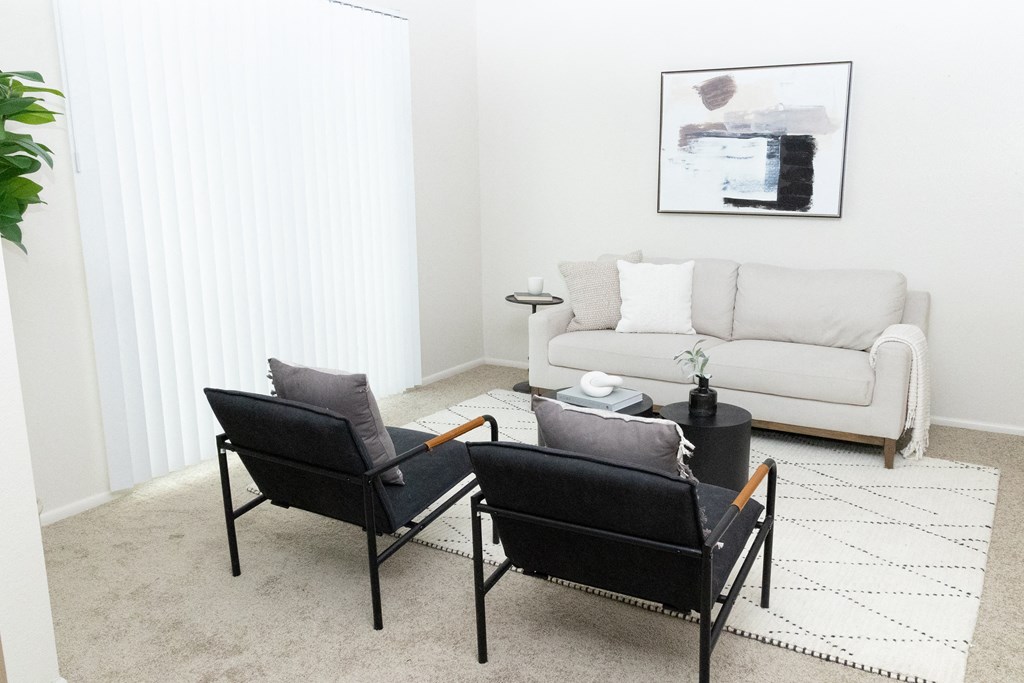 a living room with two black chairs and a white couch