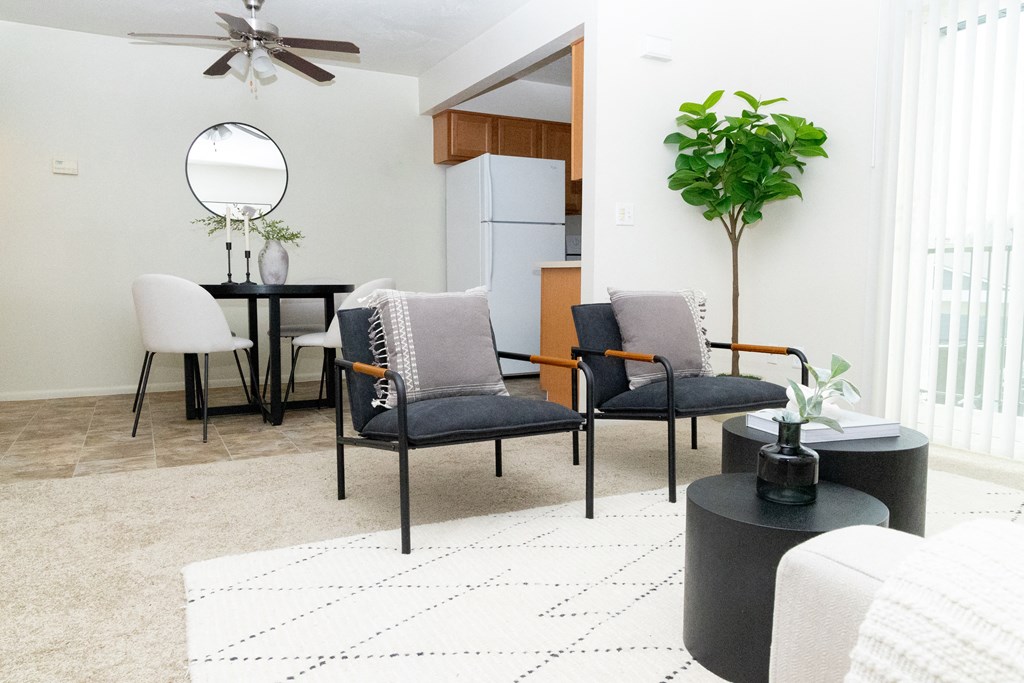 a living room with a dining area and a kitchen with a table and chairs
