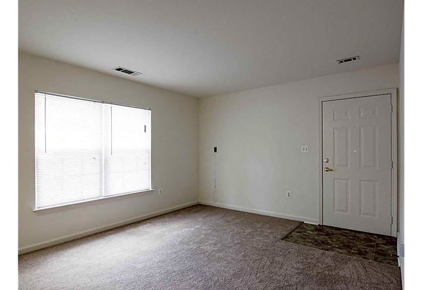 an empty room with a white door and a window