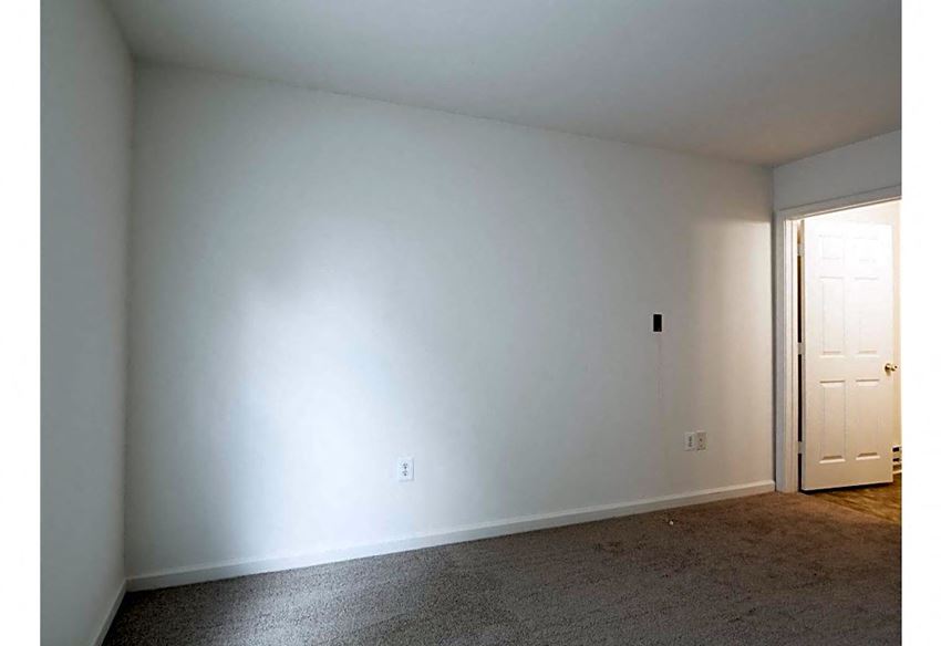 a living room with a white wall and a door