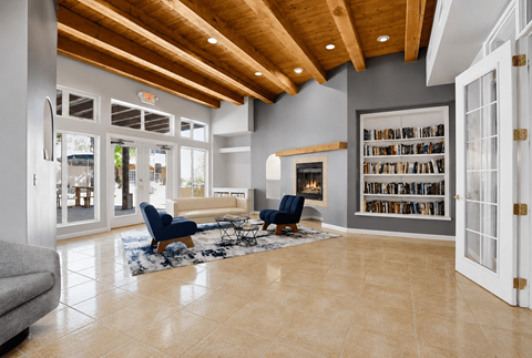 A living room with a blue chair and a fireplace.