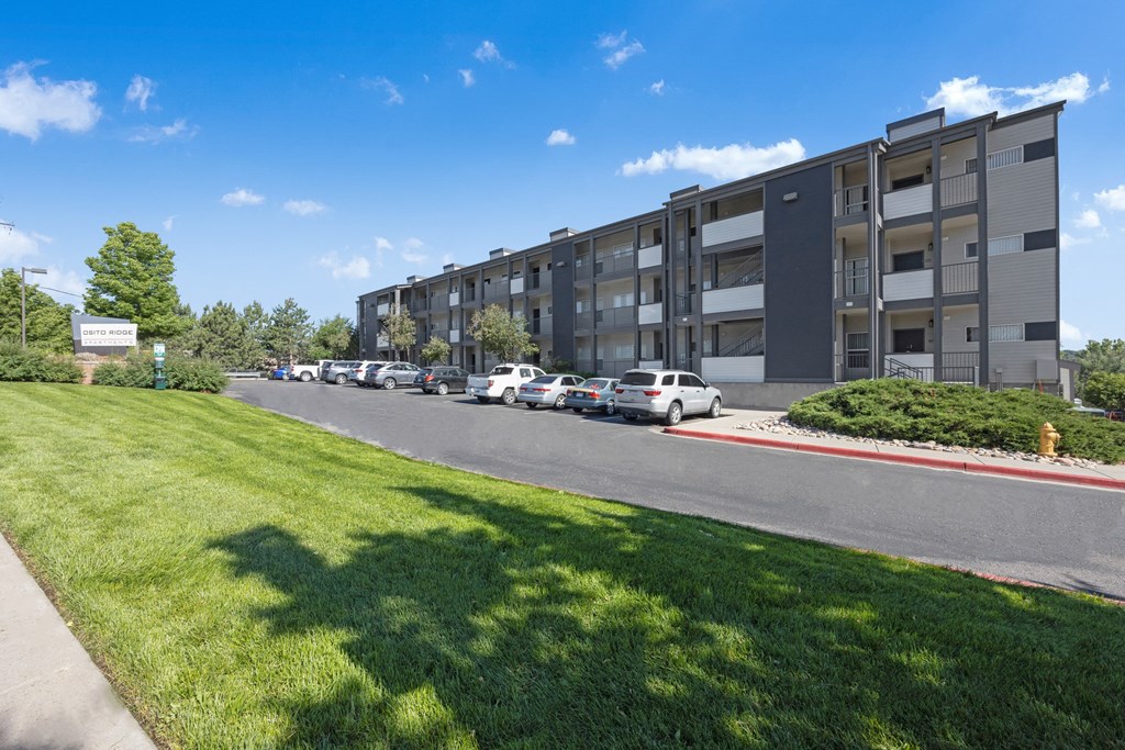 an apartment building on a street with cars parked in front of it