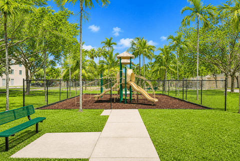 A playground with a slide and a green bench.