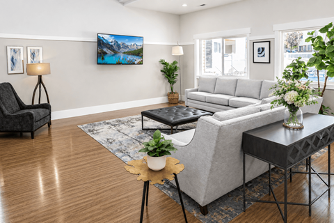 A living room with a grey couch, a black chair, and a coffee table.
