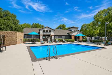 A large swimming pool in front of a house.