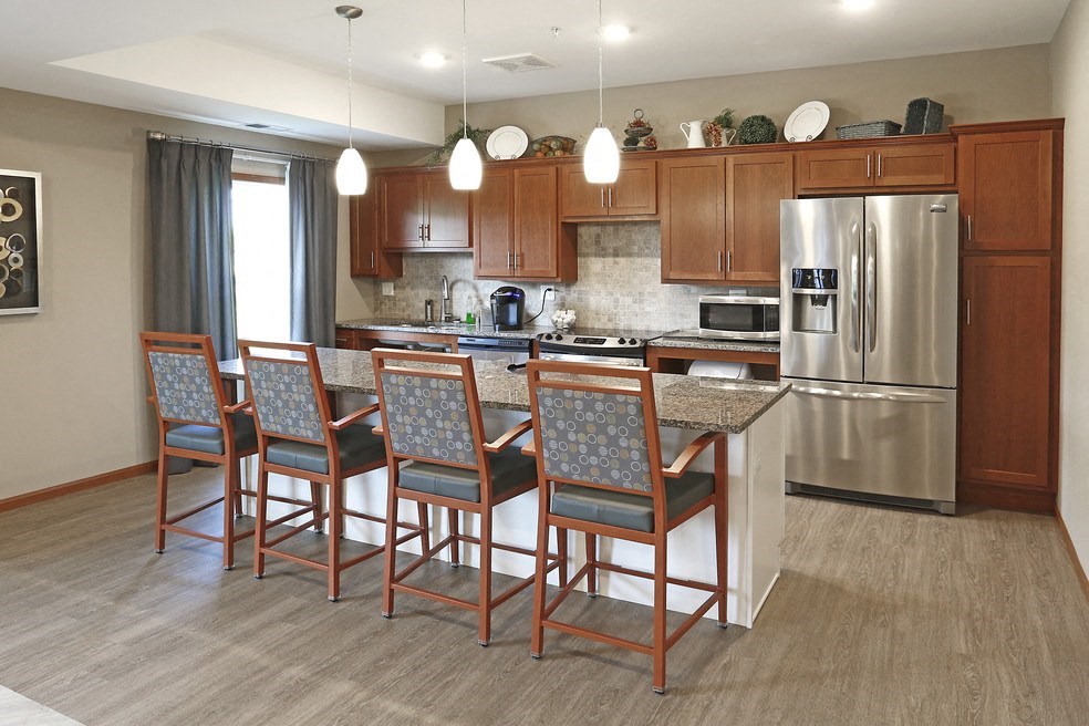 a large kitchen with stainless steel appliances and wooden cabinets
